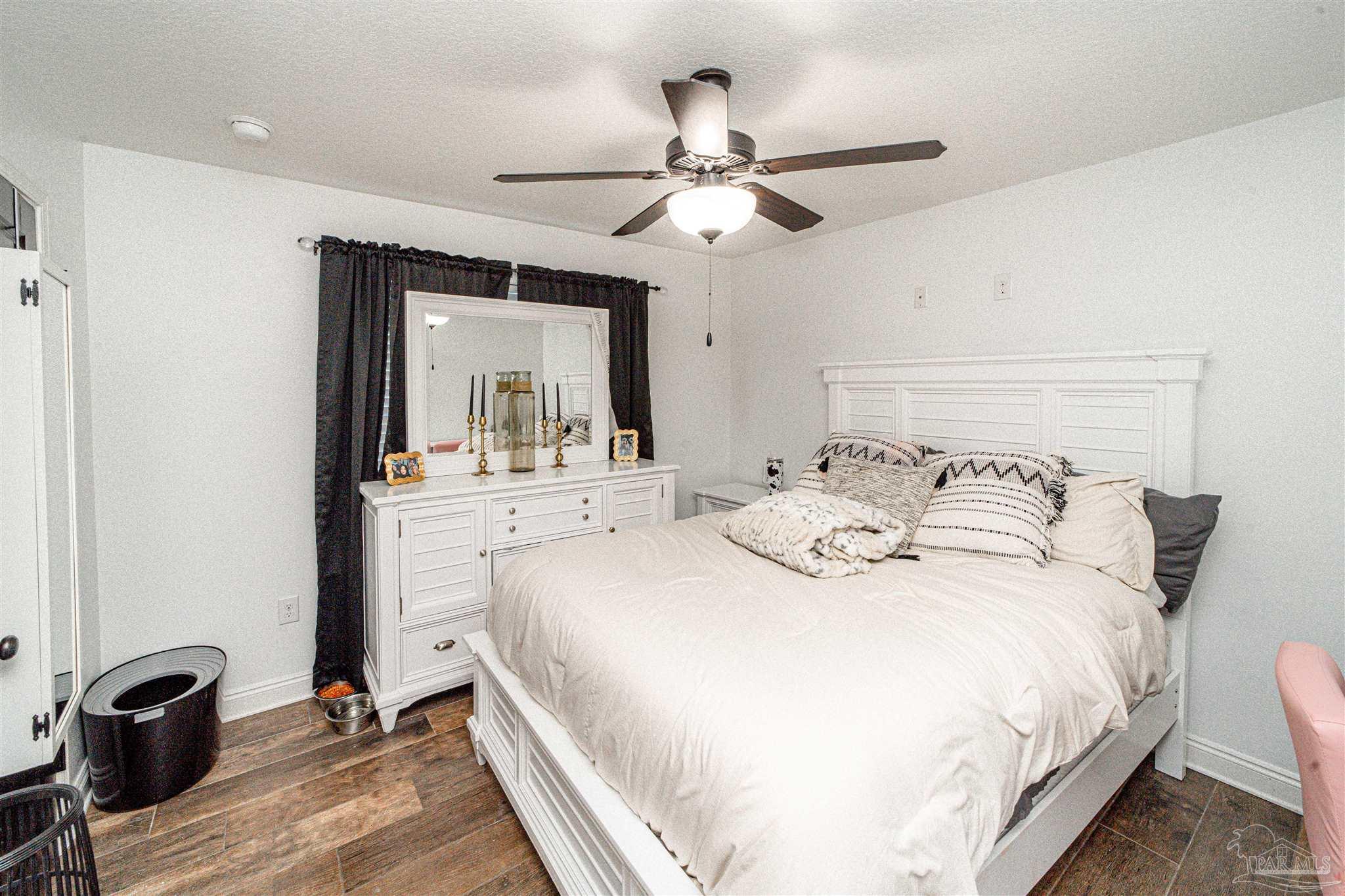 8165 Chumuckla Highway Pace, FL 32571 - Photo 38 of 50 a bedroom with a bed and a mirror