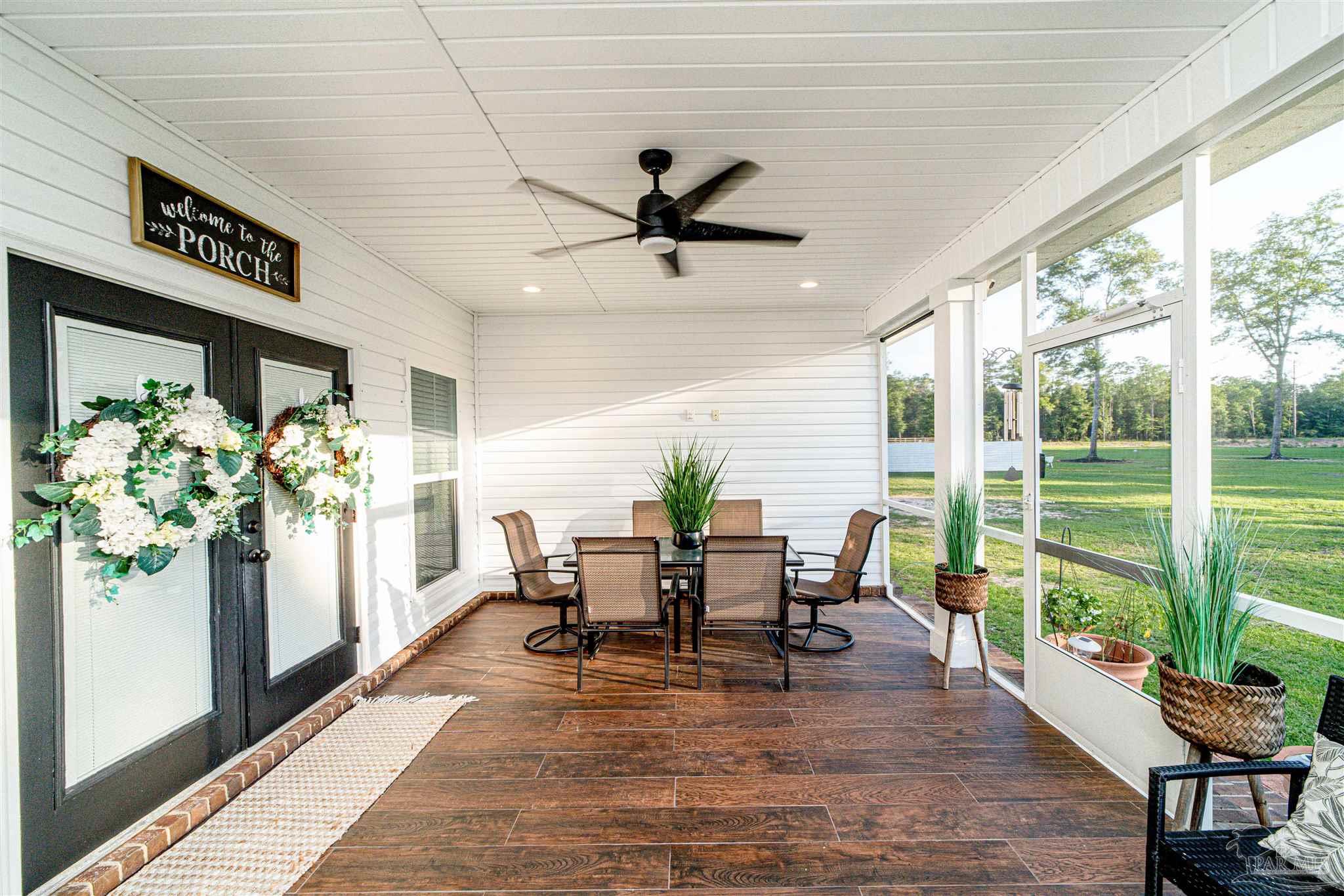 8165 Chumuckla Highway Pace, FL 32571 - Photo 44 of 50 a dining room with furniture potted plants and wooden floor