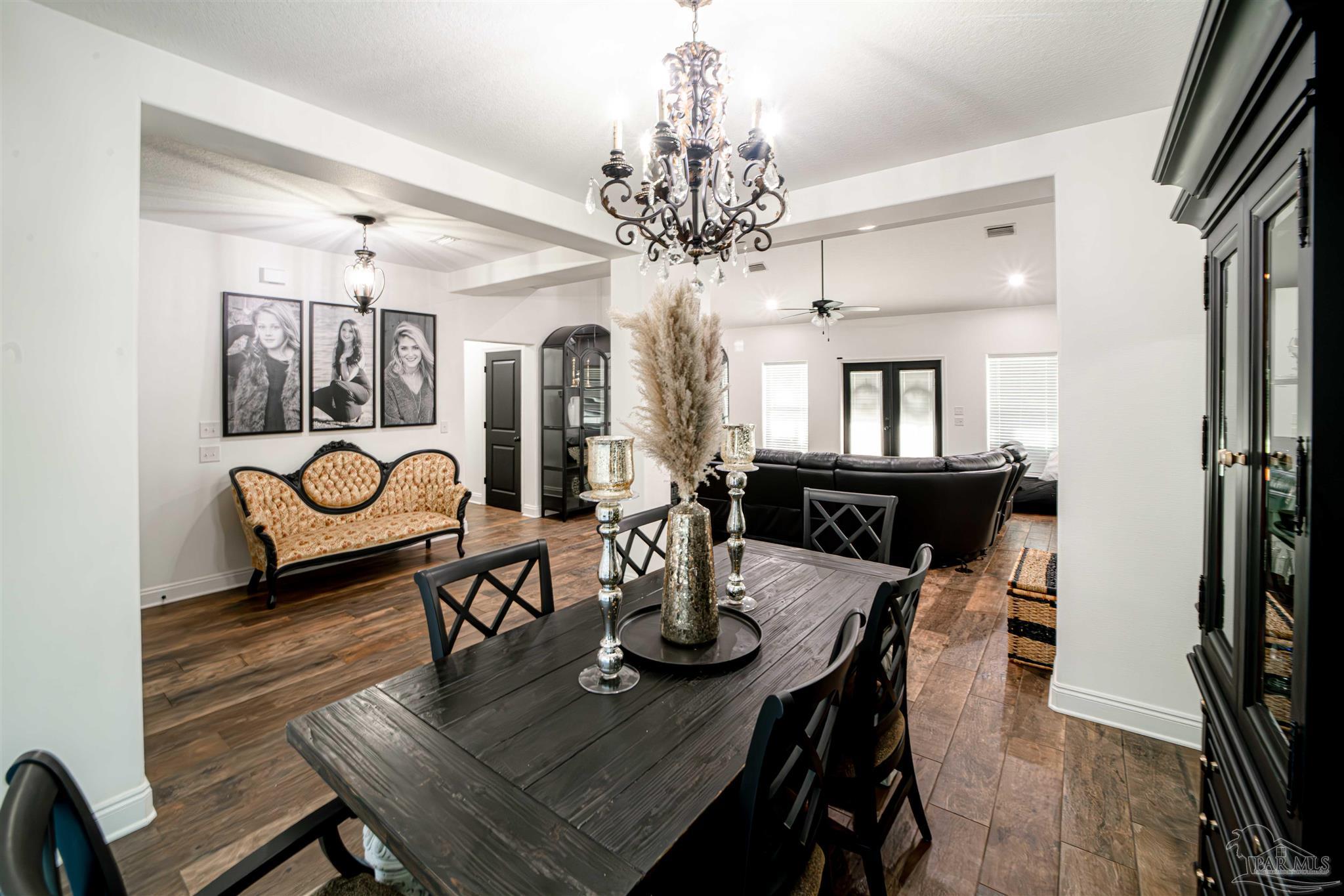 8165 Chumuckla Highway Pace, FL 32571 - Photo 9 of 50 a view of a dining room with furniture and wooden floor