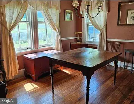 a room with wooden floor table and chairs