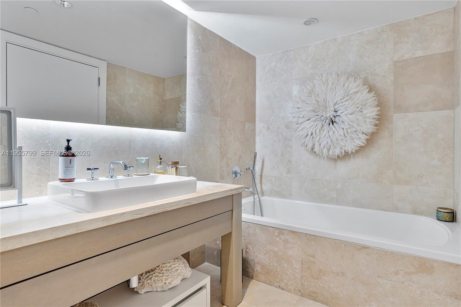 102 24th Street, Unit 1427 Miami Beach, FL 33139 - Photo 32 of 77 a bathroom with a sink a mirror and a bathtub