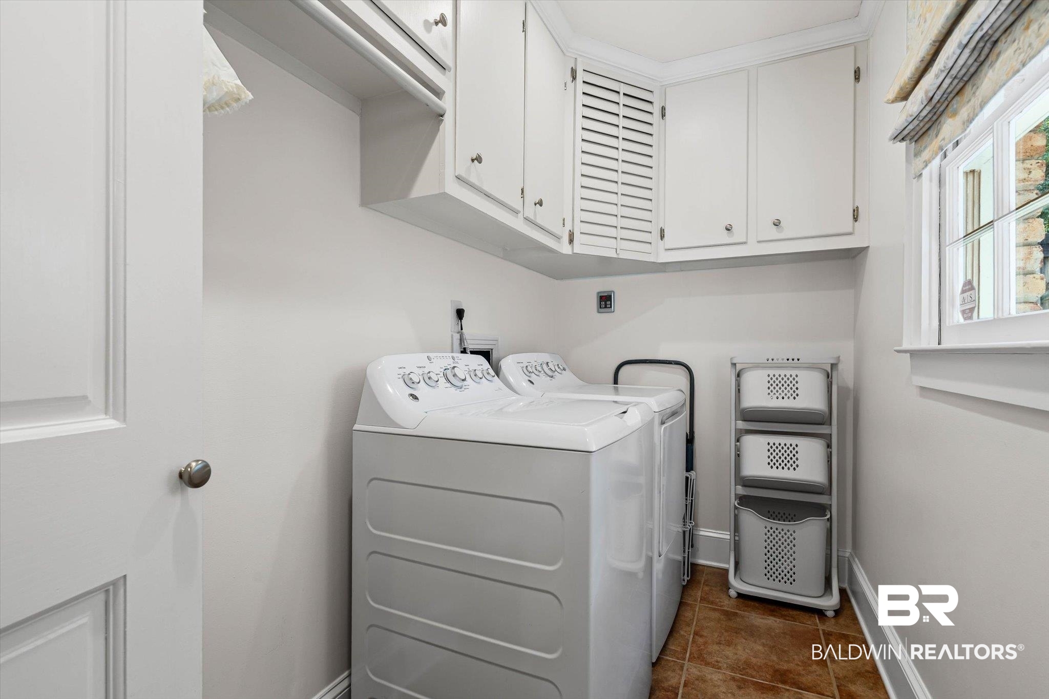 513 Spring Park Drive East Mobile, AL 36608 - Photo 16 of 44 Laundry area with cabinet space, dark tile patterned flooring, and washing machine and clothes dryer