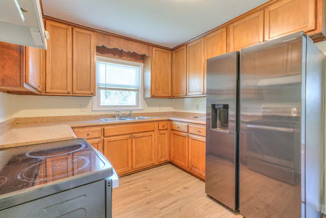 a kitchen with stainless steel appliances granite countertop a refrigerator and a sink
