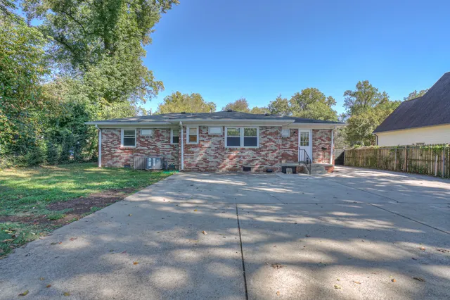 a front view of a house with a garden and lake view