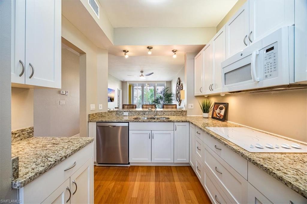 401 Bayfront Place, Unit 3404 Naples, FL 34102 - Photo 6 of 14 a view of a kitchen with kitchen island granite countertop wooden cabinets and a sink
