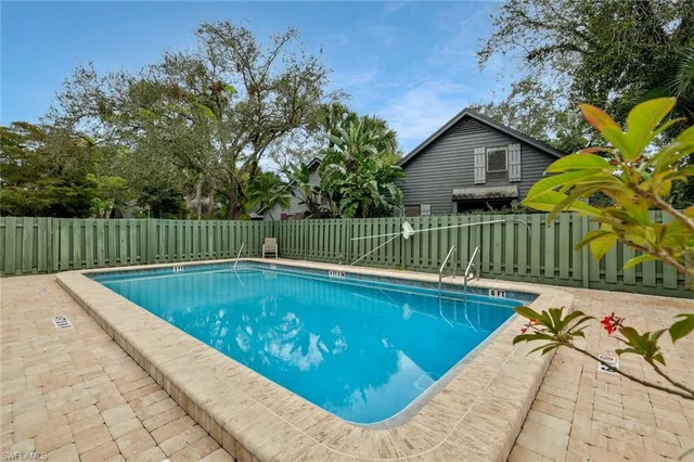 a view of a backyard with a small pool and wooden fence