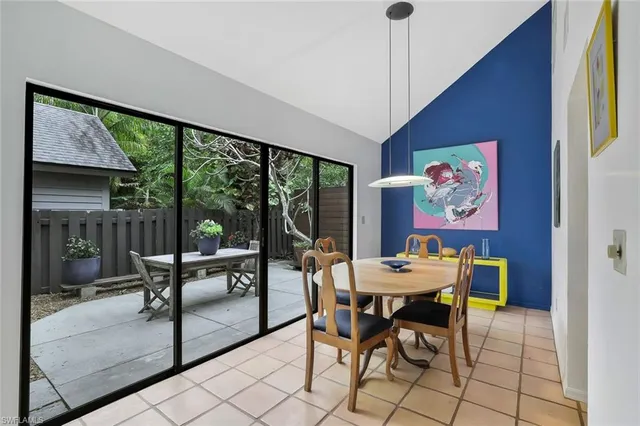 a dining room with furniture a chandelier and glass door