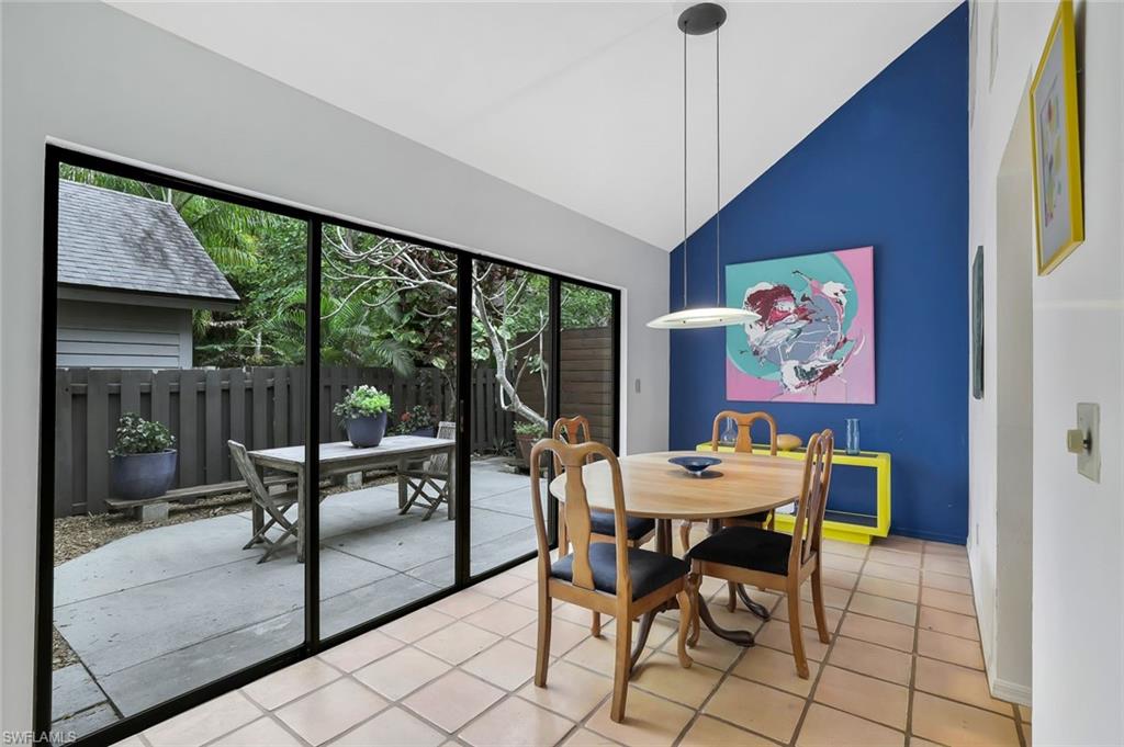 1329 Solana Road, Unit K5 Naples, FL 34103 - Photo 9 of 20 a dining room with furniture a chandelier and glass door