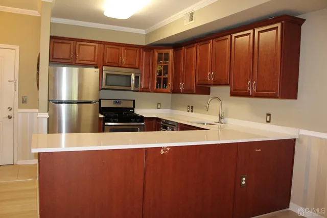 a kitchen with stainless steel appliances a refrigerator sink and cabinets