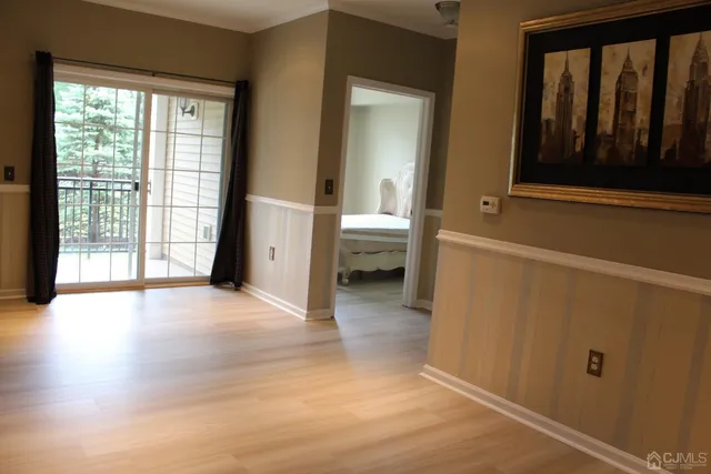 a view of a hallway with wooden floor and a bathroom