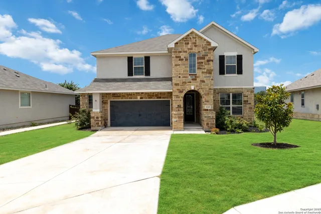 a front view of a house with a yard and garage