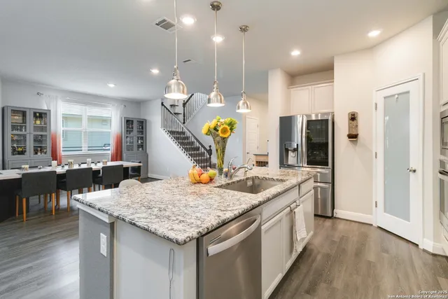 a kitchen with a sink a counter top space and stainless steel appliances
