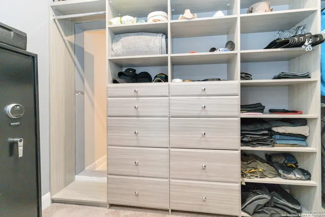 a view of walk in closet with clothes and shoes