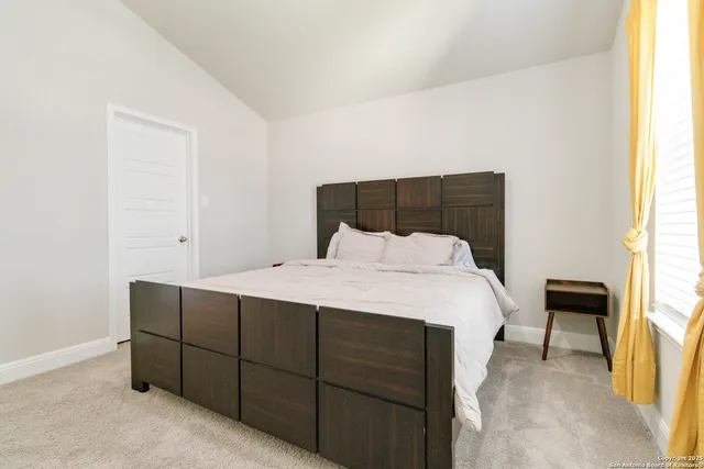 a bed sitting in a bedroom next to a window