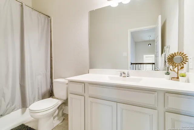 a bathroom with a sink a toilet and a mirror