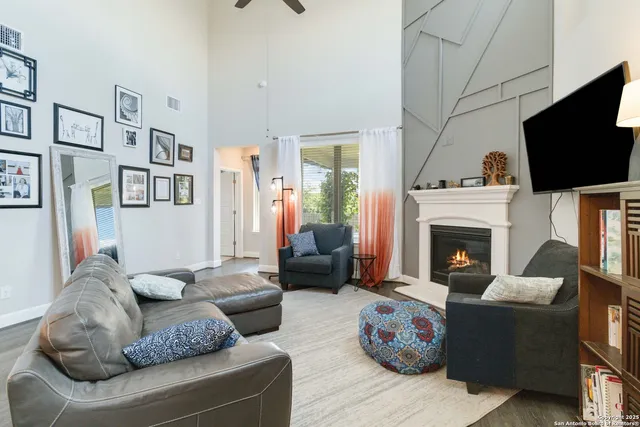 a living room with furniture a flat screen tv and a fireplace
