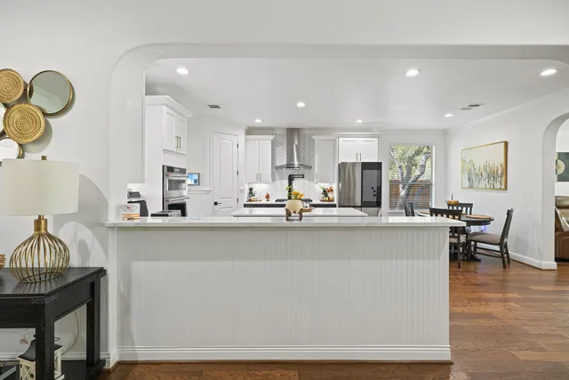 a kitchen with kitchen island stainless steel appliances a sink and a stove