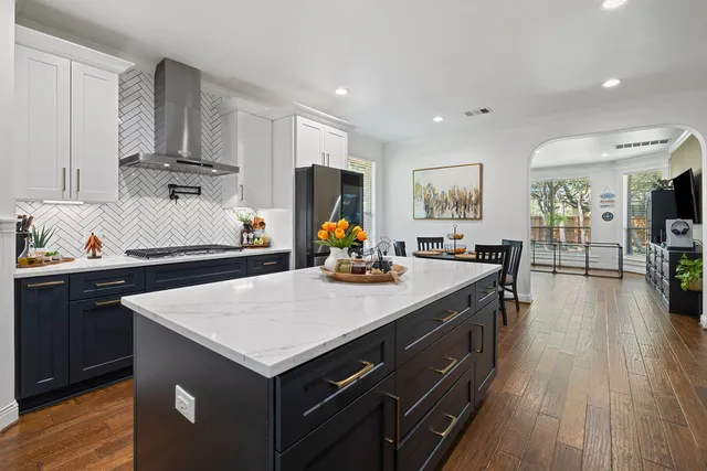 a kitchen with a stove a refrigerator and wooden floor