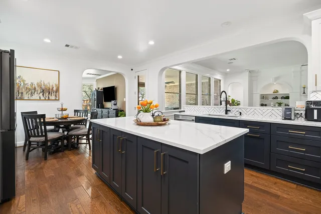a kitchen with stainless steel appliances granite countertop sink stove top oven and cabinets