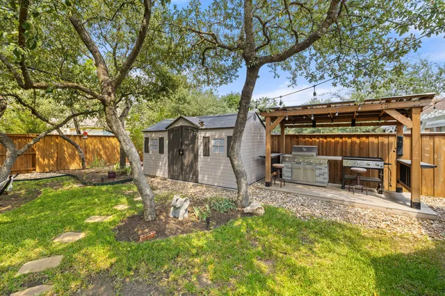 a view of a house with backyard and tree