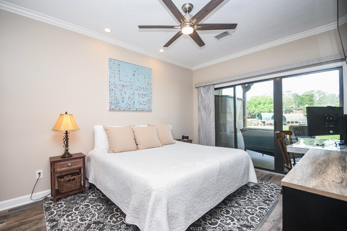 500 River Road, Unit 101 Montgomery, TX 77356 - Photo 7 of 27 primary bedroom with king sized bed and sliding door access to patio