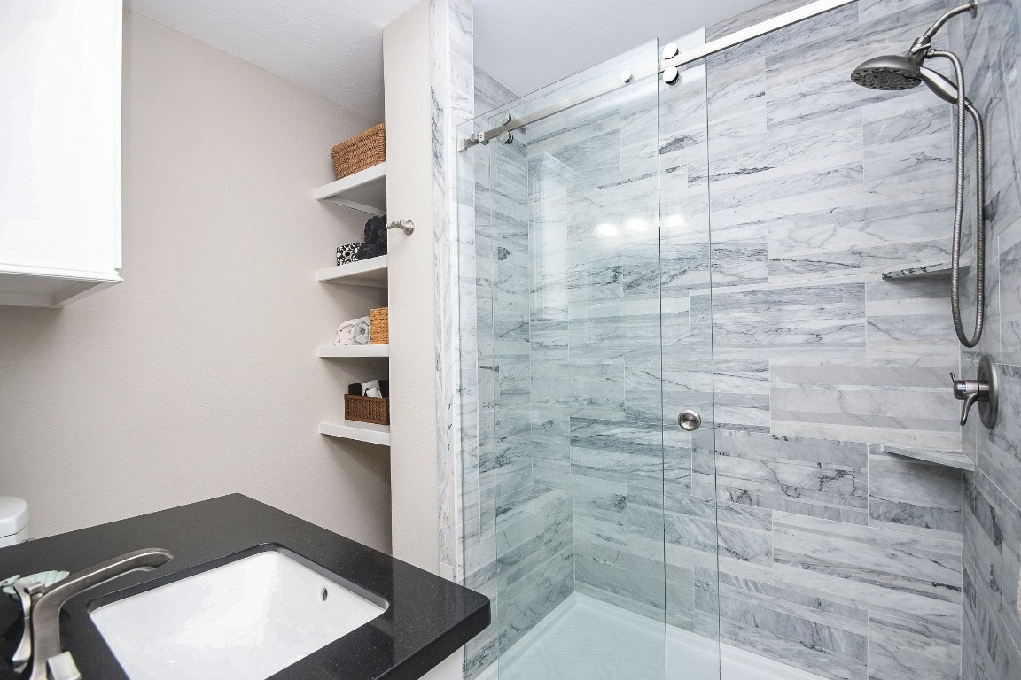 500 River Road, Unit 101 Montgomery, TX 77356 - Photo 9 of 27 Primary bath with shower bench and lots of storage shelves