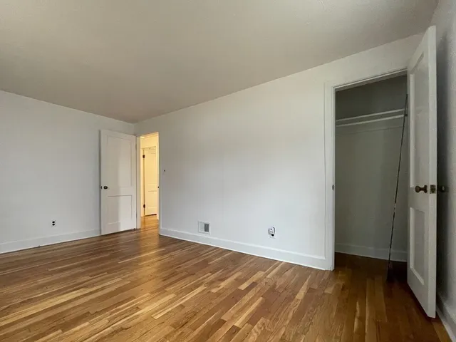 a view of an empty room and wooden floor