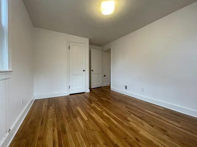 a view of a room with wooden floor and white walls