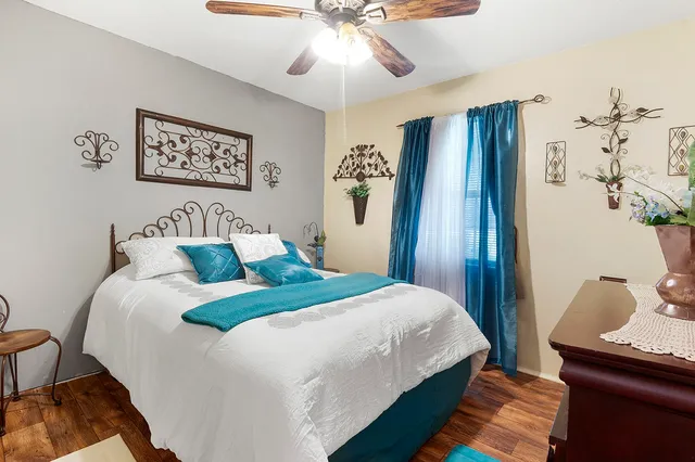 a bedroom with bed and wooden floor