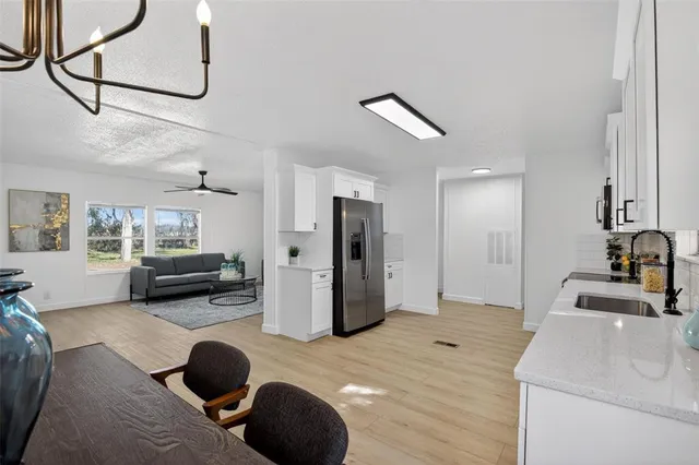 a kitchen with granite countertop a refrigerator stove top oven and sink