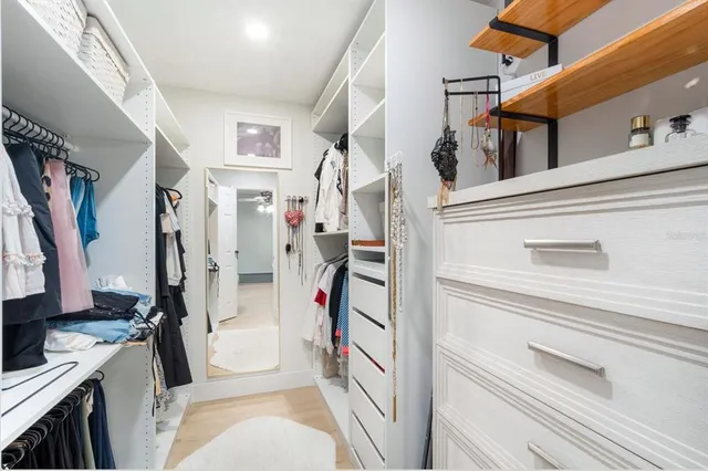 a view of walk in closet with clothes and shoes