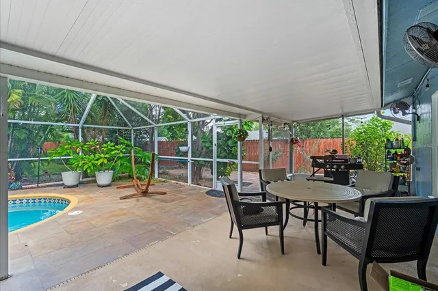 a patio with table and chairs and potted plants