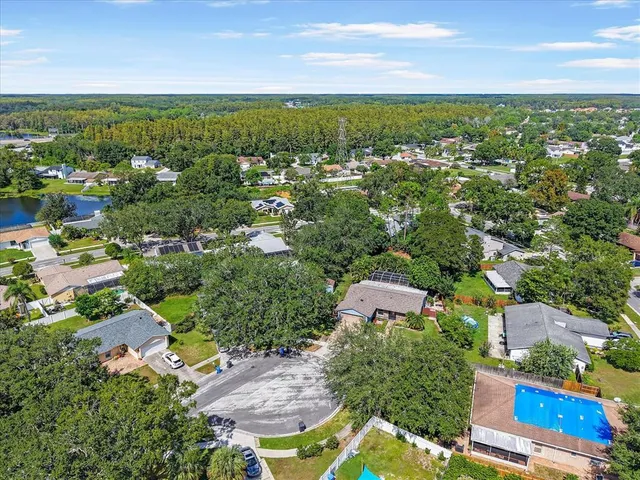 an aerial view of residential houses with outdoor space and trees