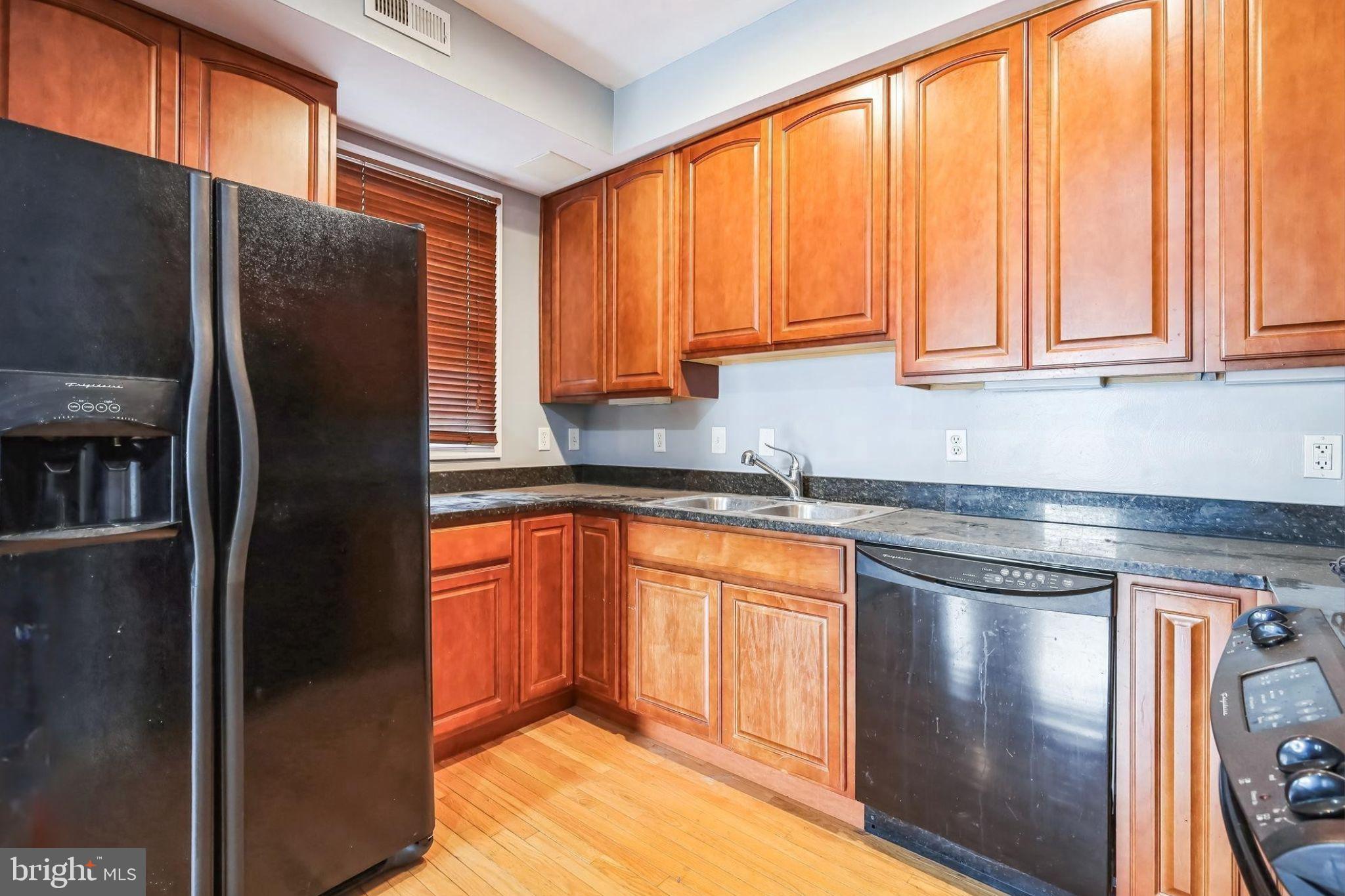 610 Irving Street Northwest, Unit 105 Washington, DC 20010 - Photo 15 of 28 a kitchen with stainless steel appliances granite countertop a refrigerator a sink a stove and island