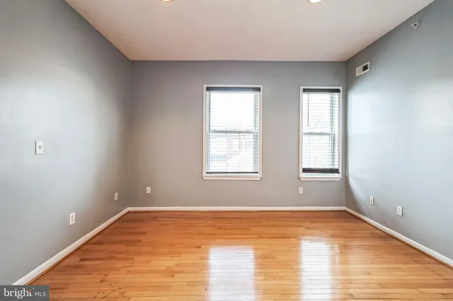a view of empty room with wooden floor