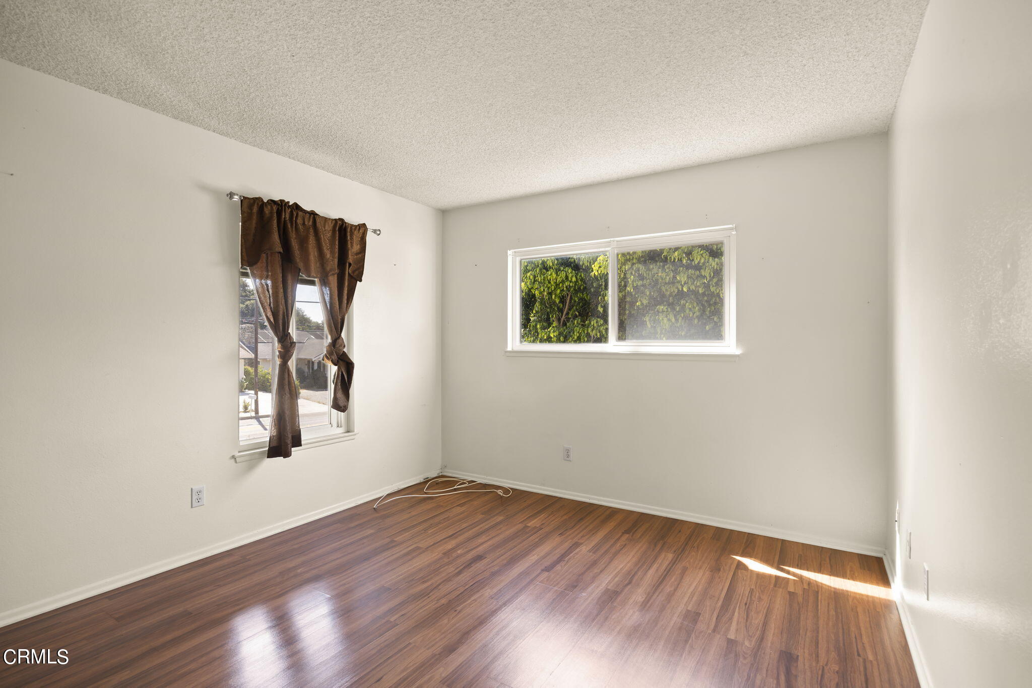 1106 Ojai Road Santa Paula, CA 93060 - Photo 16 of 45 an empty room with wooden floor and windows