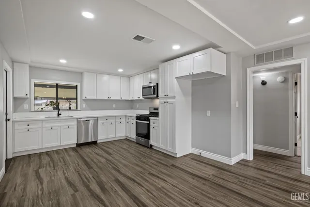 a kitchen with white cabinets and stainless steel appliances
