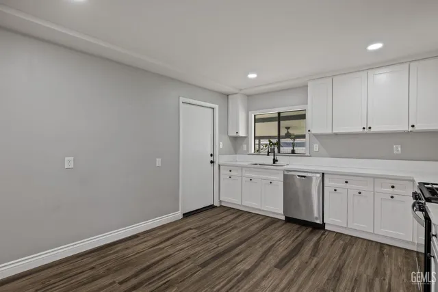a kitchen with granite countertop white cabinets and white appliances