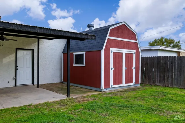 a backyard of a house with table and chairs