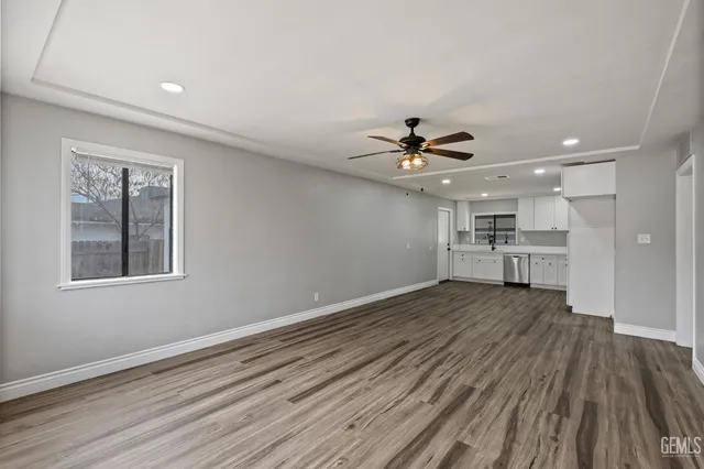a view of empty room with wooden floor and window