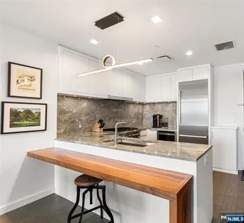 a kitchen with stainless steel appliances granite countertop a sink a stove and a refrigerator