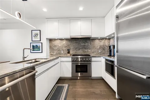 a kitchen with stainless steel appliances granite countertop a sink and a stove top oven