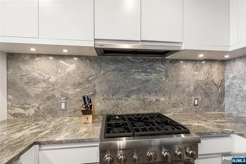 a kitchen with granite countertop a stove and a sink
