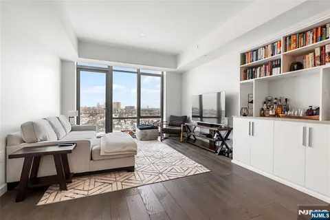 a living room with furniture hard wood floor and a book shelf