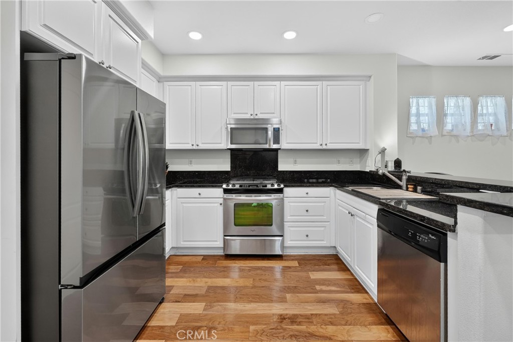 849 The Promenade, Unit D Azusa, CA 91702 - Photo 13 of 37 a kitchen with stainless steel appliances granite countertop a refrigerator and a stove