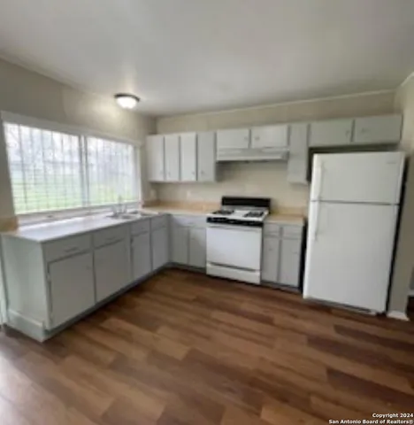 a kitchen with a sink a window and stainless steel appliances