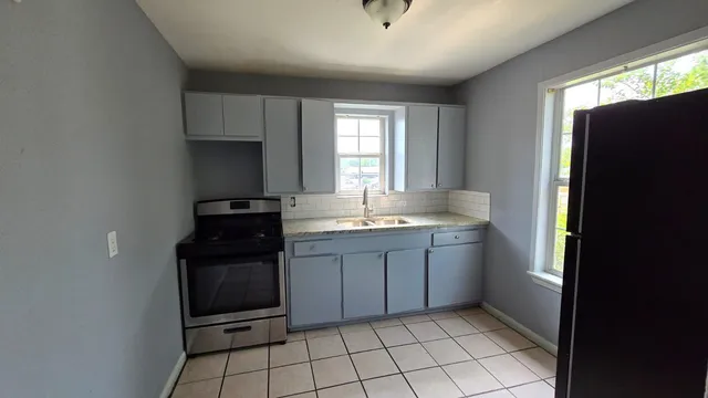 a kitchen with granite countertop a refrigerator and a sink