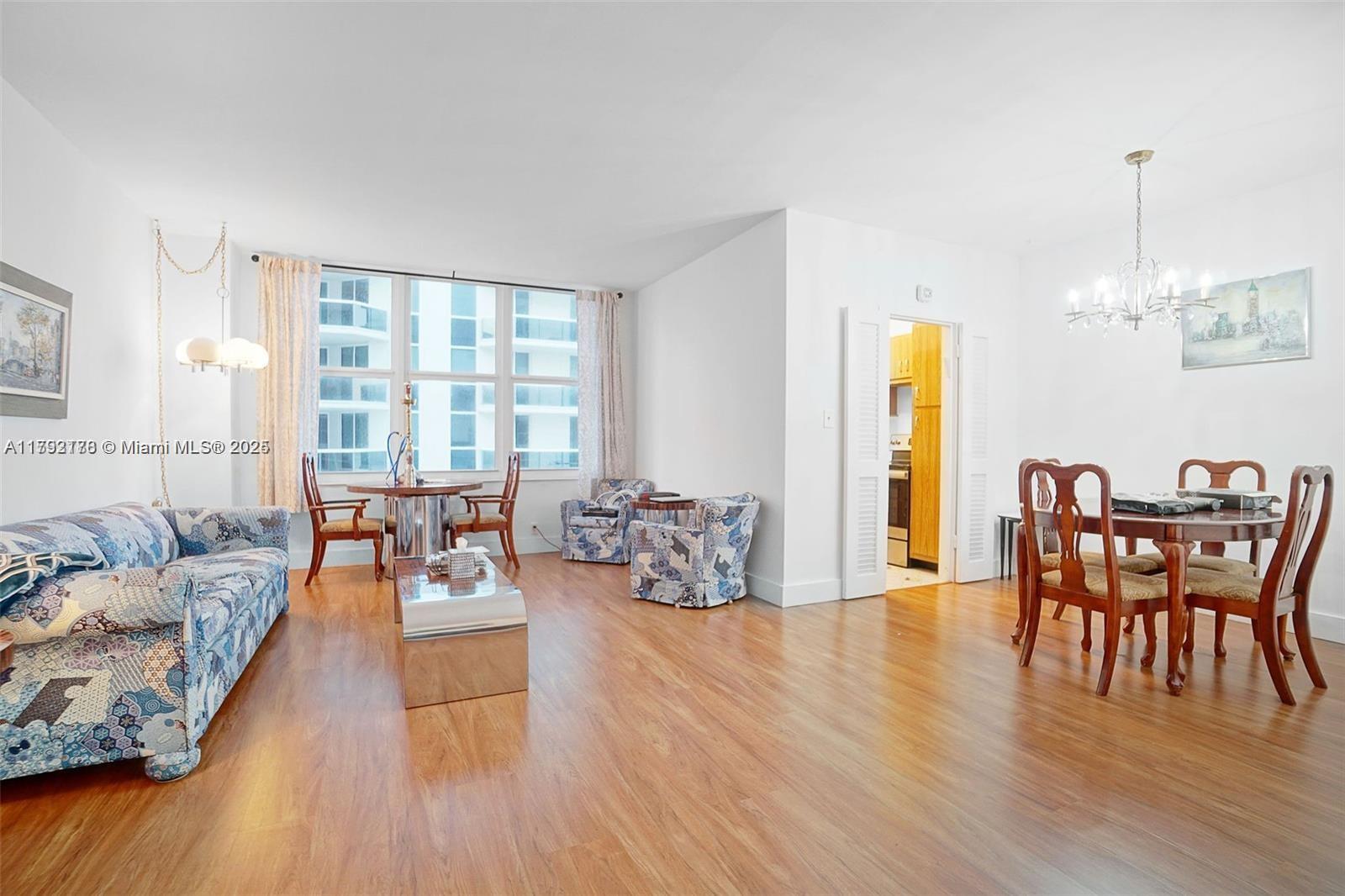 a living room with furniture dining table and a large window