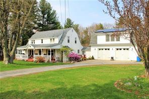a front view of a house with a garden and trees
