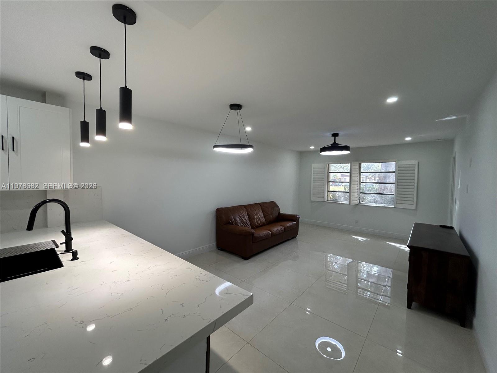 300 Berkley Road, Unit 108 Hollywood, FL 33024 - Photo 13 of 41 a kitchen with a sink and chandelier